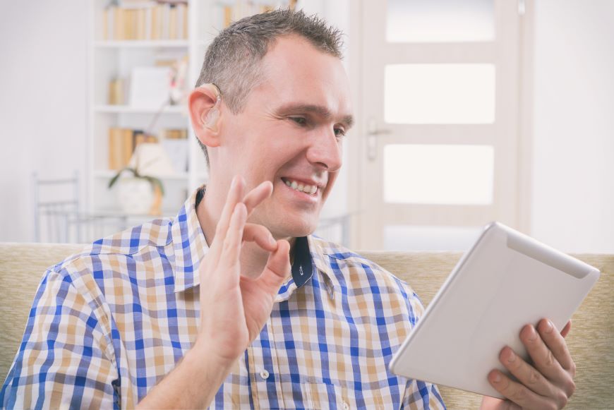 Man signing holding Ipad