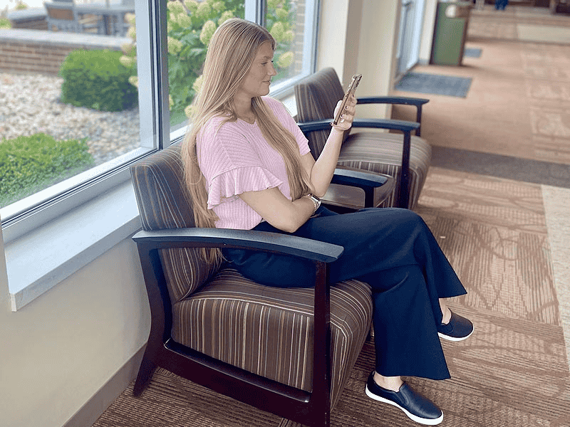 Girl on Chair Looking At Phone